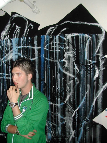 Dave in front of a wall of painted t-shirts.